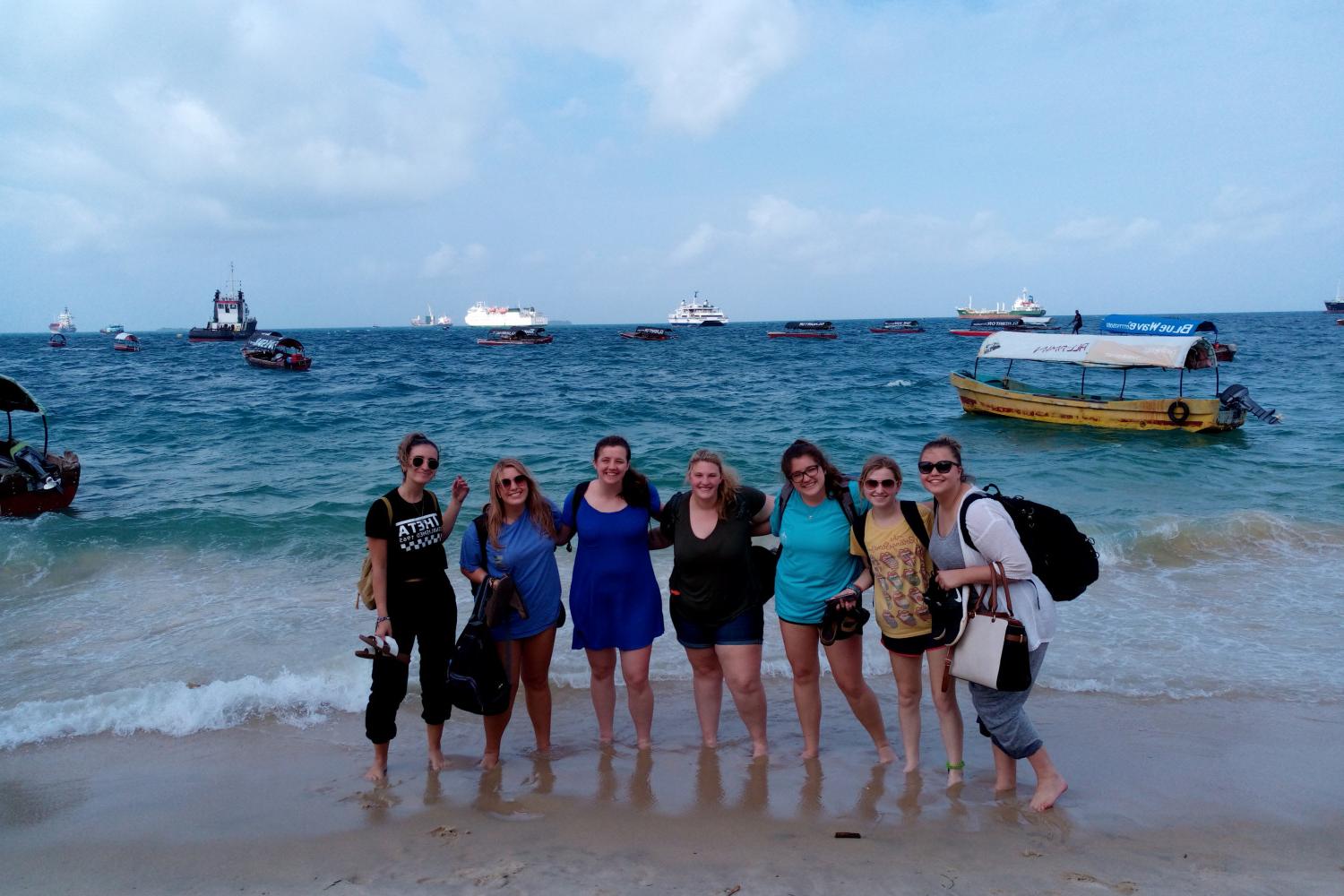 在坦桑尼亚的j学期游学活动中，学生们在海边摆姿势拍照.